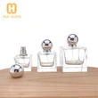 Frascos de perfume decorativos de forma cuadrada con tapa de bola plateada.