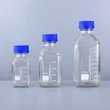 Botellas cuadradas de vidrio ámbar y transparente, resistentes a productos químicos, para uso en laboratorio.