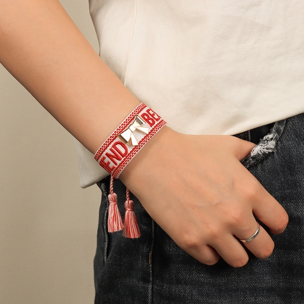 Tassel bracelets featuring embroidered words and decorative charms- rose, butterfly, clover, and bow