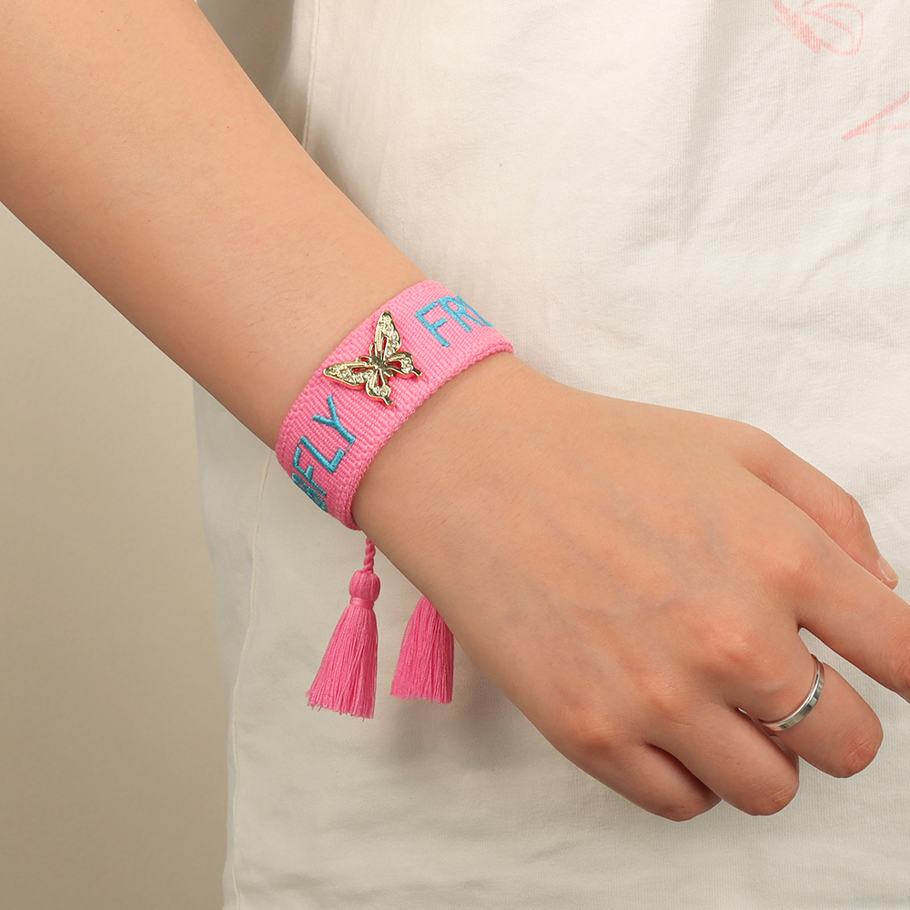 Tassel bracelets featuring embroidered words and decorative charms- rose, butterfly, clover, and bow