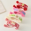 Tassel bracelets featuring embroidered words and decorative charms- rose, butterfly, clover, and bow