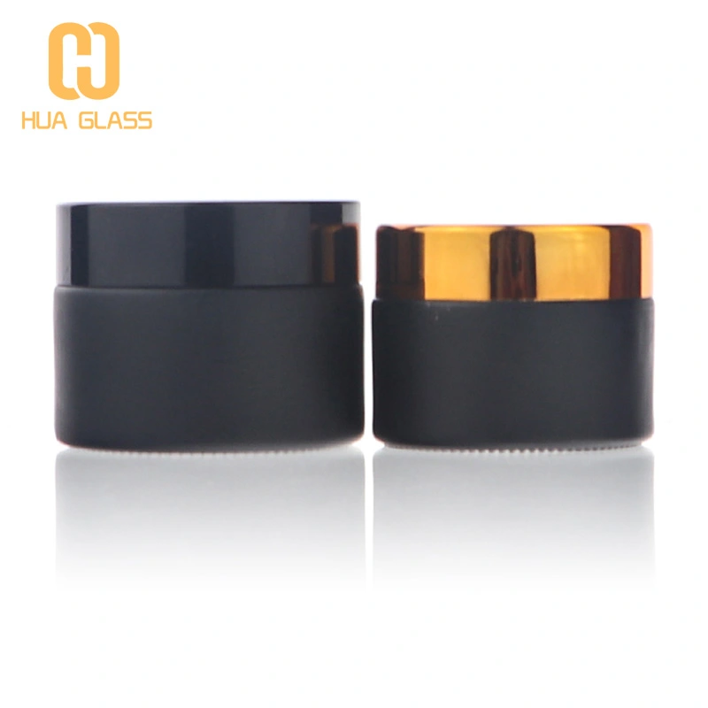 матовые черные плоские косметические стеклянные бутылки и банки с кремом на плечах