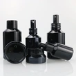 hot sale cosmetic glass bottle and jar with black frosted amber color and pump spray dropper for essential oil serum packaging
